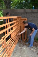 Navy Petty Officer First Class Brittney Waddell, left, and Navy Petty Officer First Class Annalynn Lawe paint the entrance gates at the Crosby Arboretum on May 8. About 20 Navy volunteers from the Stennis Space Center helped complete several large projects for the Picayune public garden before the arboretum's busy summer season.