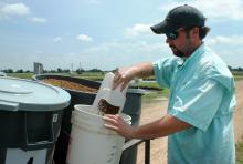 Nolan Brooks measures out catfish feed as part of a research project at MSU's Delta Research and Extension Center in Stoneville. (Photo by Rebekah Ray)