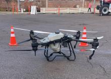 A large drone is displayed in a parking area.