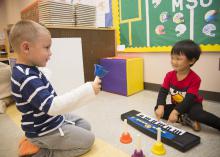 These two preschoolers play their first musical instruments in the Child Development and Family Studies Center at Mississippi State University. (School of Human Sciences file photo/Alicia Barnes)