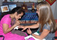 Aparna Krishnavajhala of India applies a henna tattoo on the hand of Ainsley Young, a Lee County 4-H member, during the first International Village, held during state 4-H Congress at Mississippi State University on May 27, 2015. (Photo by MSU Ag Communications/Linda Breazeale)