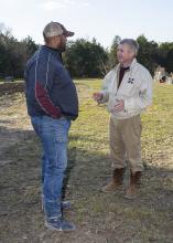 Scott Ross, right, talks with B.J. McClenton, an agent with the Mississippi State University Extension Service in Clay County, about his 50-acre pasture pig operation. (Photo by MSU Ag Communications/Kevin Hudson)