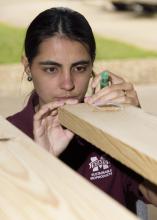 Tamara Amorim, a graduate student at Mississippi State University, measures a piece of lumber at the MSU Forest Products Laboratory as part of a large-scale research project designed to enhance the value of Southern forests. (MSU Extension Service/Kevin Hudson)