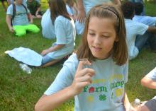 Adara Blalock, 10, visits with a grasshopper (or vice versa) while taking a break during the Adams County Farm Camp near Natchez, Mississippi, on July 7, 2016. (Photo by MSU Extension Service/Linda Breazeale)