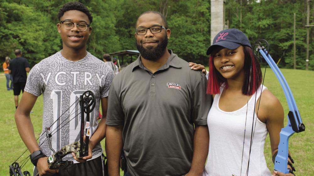 Robert Rice, 4-H volunteer leader and two 4-Hers A 4-H volunteer leader with two 4-H members at a 4-H Shooting Sports event.