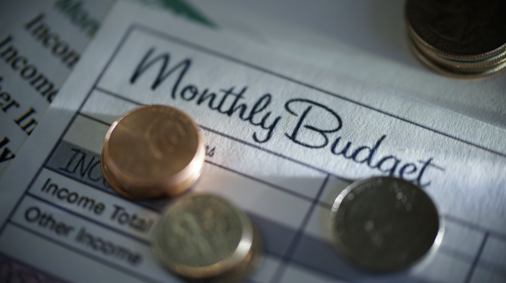 Coins stacked on a monthly budgeting form.