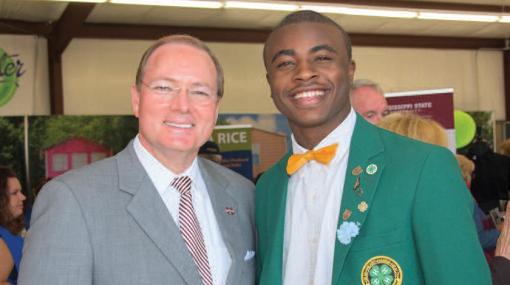 MSU President Mark Keenum stands next to a young man in a green 4-H blazer.