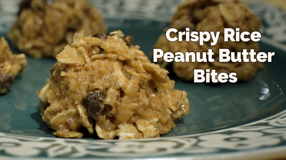 Four Crispy Rice Peanut Butter Bites made with oats, peanut butter, mini chocolate chips, crispy rice cereal, and honey sit on a small dark turquoise plate with a floral border.