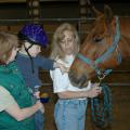 Oktibbeha County Hospital physical therapist Glenda Tranum holds Preston Cook, age 3, up to pet his therapy horse before a recent hippotherapy session at the Mississippi Horse Park. Denise Latil helped handle the horse throughout the session. The Mississippi State Extension Service 4-H TEAM (Therapeutic Equine Activity Member) Program is one of two accredited therapeutic riding programs in the state. 