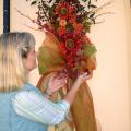 Create unique decorations and gifts for less using resources from gardens, fields and woods. Lelia Kelly puts the finishing touches on a door swag she made using crape myrtle seed pods, nandina foliage and berries, English ivy and bare branches, highlighted with silk sunflowers and other silk materials. (Photo by Vickie McGee)
