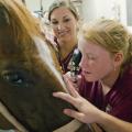 Mississippi State University College of Veterinary Medicine student Susannah Brent, left, shows vet camp participant Santana Shelton how to use an ophthalmoscope to examine a horse's eye. (Photo by MSU College of Veterinary Medicine/Tom Thompson)