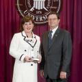 Deputy State Veterinarian and Public Health Veterinarian Dr. Brigid Elchos, left, accepts her alumnus of the year award from Dr. Kent Hoblet, dean of Mississippi State University College of Veterinary Medicine. Elchos received the honor because of her outstanding achievements and leadership. (Photo by MSU University Relations/Megan Bean)