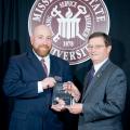 Dr. Locke Karriker, director of the Swine Medicine Education Center at Iowa State University, left, receives the 2012 College of Veterinary Medicine Alumnus of the Year award at Mississippi State University from Dr. Kent Hoblet, the college's dean. (Photo by MSU University Relations/Russ Houston)