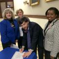 Mississippi State University Extension Service health specialist David Buys signs a pledge to be screened for colorectal cancer in 2015. Other representatives of the MSU Extension Service, Ann Sansing (from left), Theresa Hand and Natasha Haynes, are joining him in the awareness event at the Mississippi Capitol on March 9, 2015. (Submitted photo)