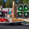 A plate of strawberries and pretzels beside a glass 4-H emblem.