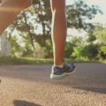 A person running with purple tennis shoes on. 