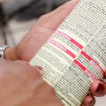 A closeup of a woman's hands holding a pesticide container while reading the instructions.
