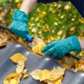 Closeup of a person cleaning leaves out of a gutter.