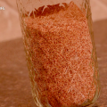 A pint glass jar filled with homemade taco seasoning sits on a kitchen countertop.