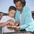 Eight-year-old Collin McWhorter and other military youth work with Lowndes County Master Gardener intern Alma Greer to plant seeds for a garden at the Columbus Air Force Base youth center as part of the Welcome Home Garden program sponsored by 4-H and the Burpee Seed Co. (Photo by MSU Ag Communications/Scott Corey)