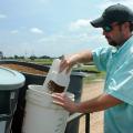 Nolan Brooks measures out catfish feed as part of a research project at MSU's Delta Research and Extension Center in Stoneville. (Photo by Rebekah Ray)