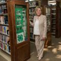 U.S. Senator Cindy Hyde-Smith stands next to a display case in a library.