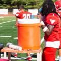 Football player getting water from a cooler.