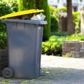 Full trash can sitting at the curb awaiting collection