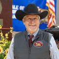 Auctioneer wearing a cowboy hat is smiling.