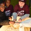 Third-graders from Houston Upper Elementary School, including, from left, Jamyrie Davenport, Sedrick Walker and R.J. Utz, pet a baby chicken held by a volunteer at the Mississippi State University Extension Service FARMtastic event at the Mississippi Horse Park near Starkville on Nov. 13, 2014. (Photo by MSU Ag Communications/Kevin Hudson)