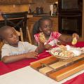 Six-year-old Jordan Ross and 8-year-old Nyema Johnson of Columbus enjoy choosing fun summer treats -- frozen banana pops dipped in either vanilla yogurt or almond bark. (Photo by MSU Ag Communications/Kat Lawrence)