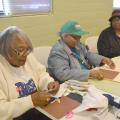 Annette Lockett, left, Thelma Washington and Mary Kohn, members of a newly formed Mississippi Homemaker Volunteers Club in Holmes County, cut out and sew quilt squares as part of a quilt-making project on Nov. 24, 2015. The group donated 67 lap quilts to residents at the Lexington Manor Senior Care facility. (Photo by MSU Ag Communications/Susan Collins-Smith)