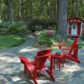 Red can be a difficult color to use in gardens, and the secret to its success sometimes lies in using it as an accent. The first thing that catches the eye in this outdoor room is the bright red Adirondack chairs. A short walk away is an idyllic children's play house of the same color. (Photo by Norman Winter)