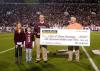 BankFirst made a donation to the Catch-A-Dream Foundation every time the Mississippi State University Bulldogs scored touchdowns. BankFirst's Jerry Wilson, left, presents a ceremonial check for $10,000 to Marty Brunson at the MSU-Arkansas game Nov. 20. Wilson is accompanied by his grandchildren, Mauri and Miller Wilson. (Photo by MSU Ag Communications/Kat Lawrence)