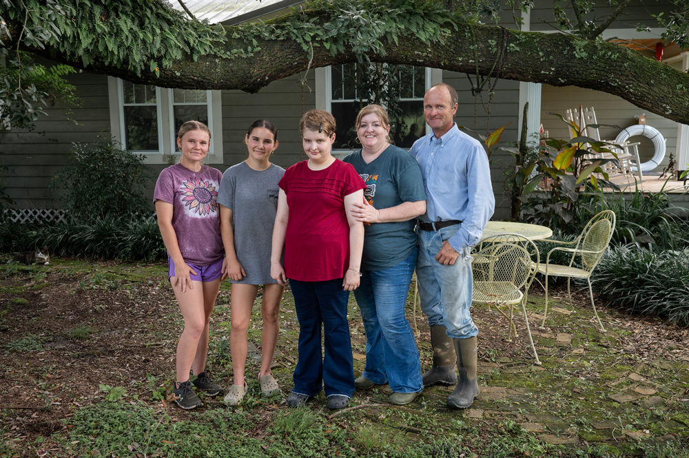Three children standing with two adults.