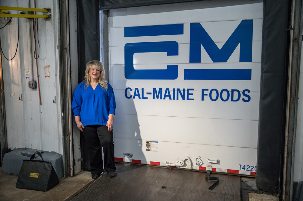 A woman standing in a loading dock with Cal-Maine Foods listed on the dock door.