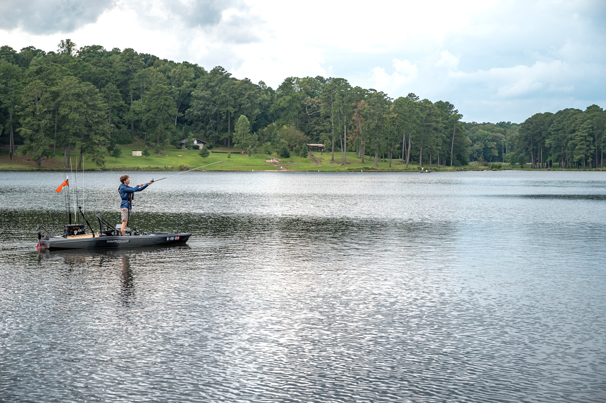 A young person fishing on a lake.