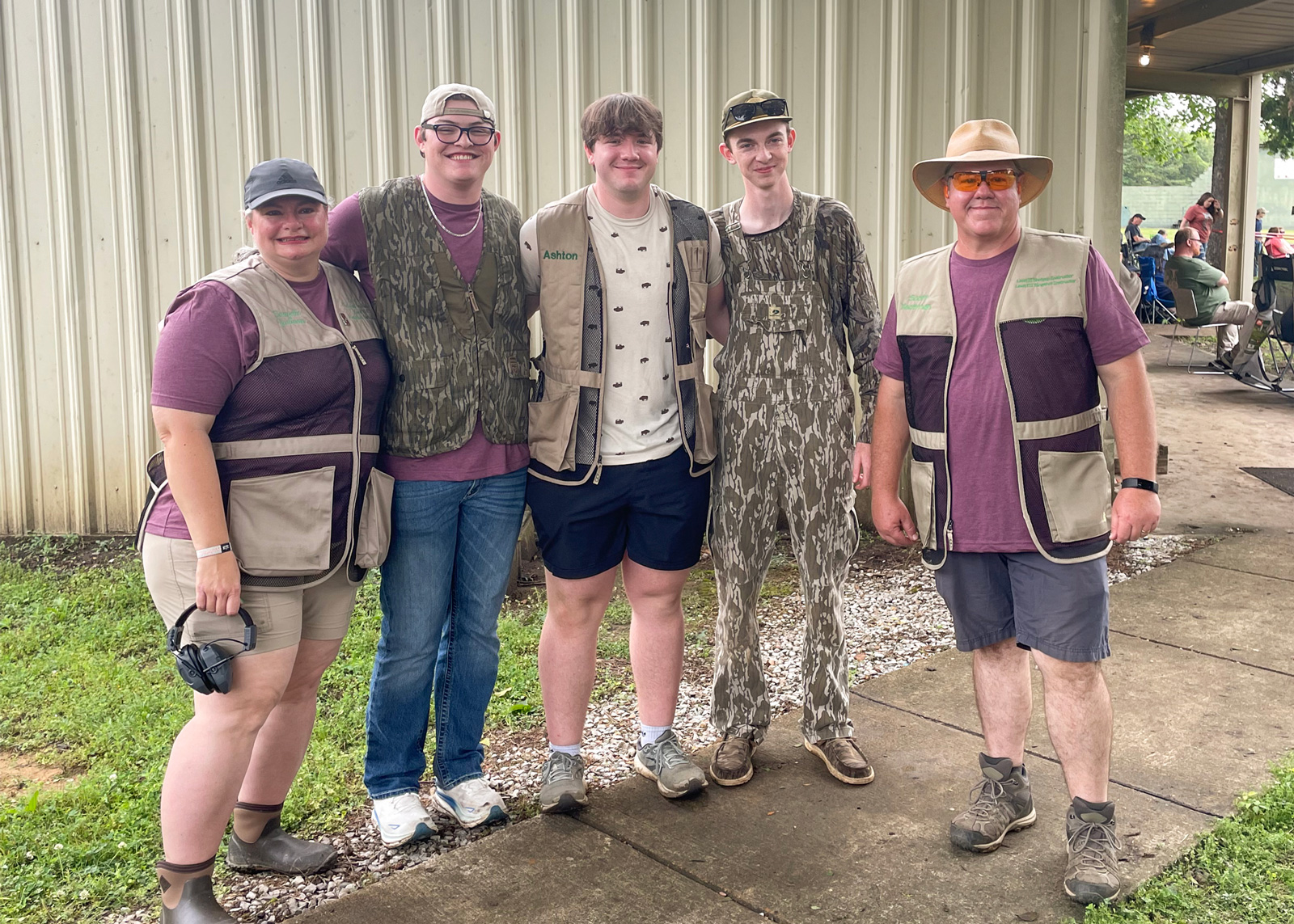Five people standing outside smiling.