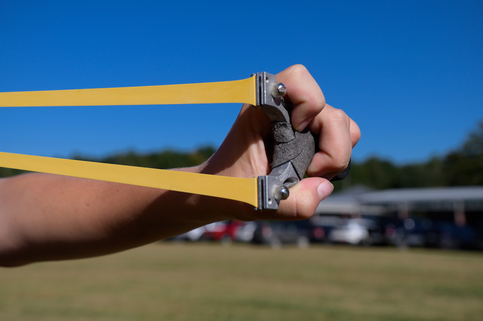 A hand holding a stretched out slingshot.