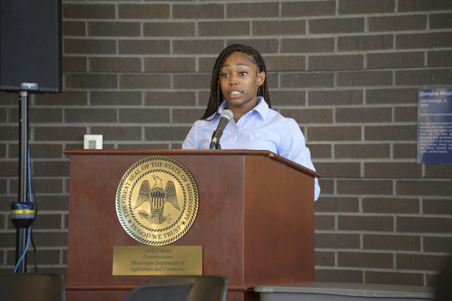 A young person speaking at a podium.