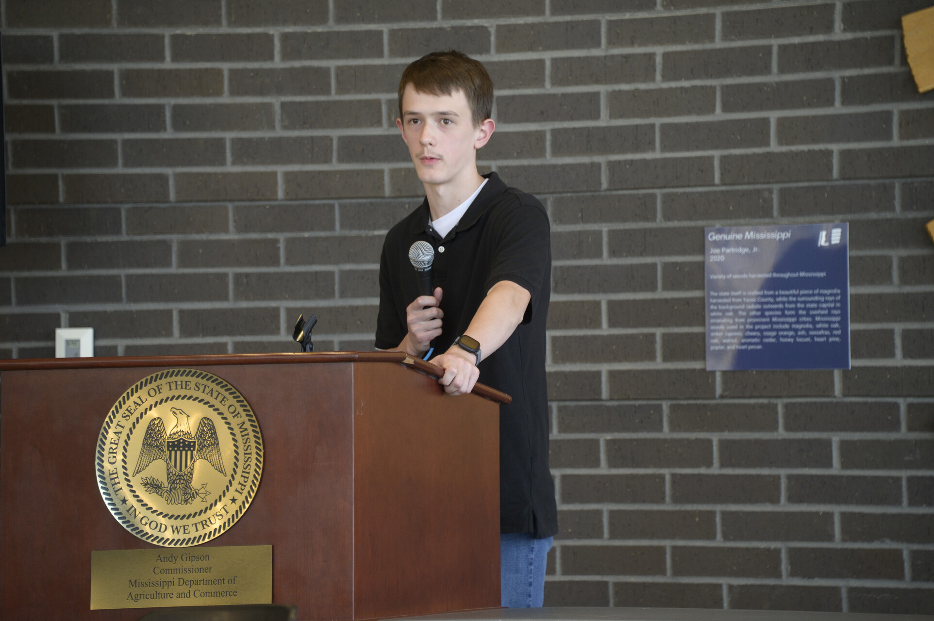 A young person speaks at a podium.
