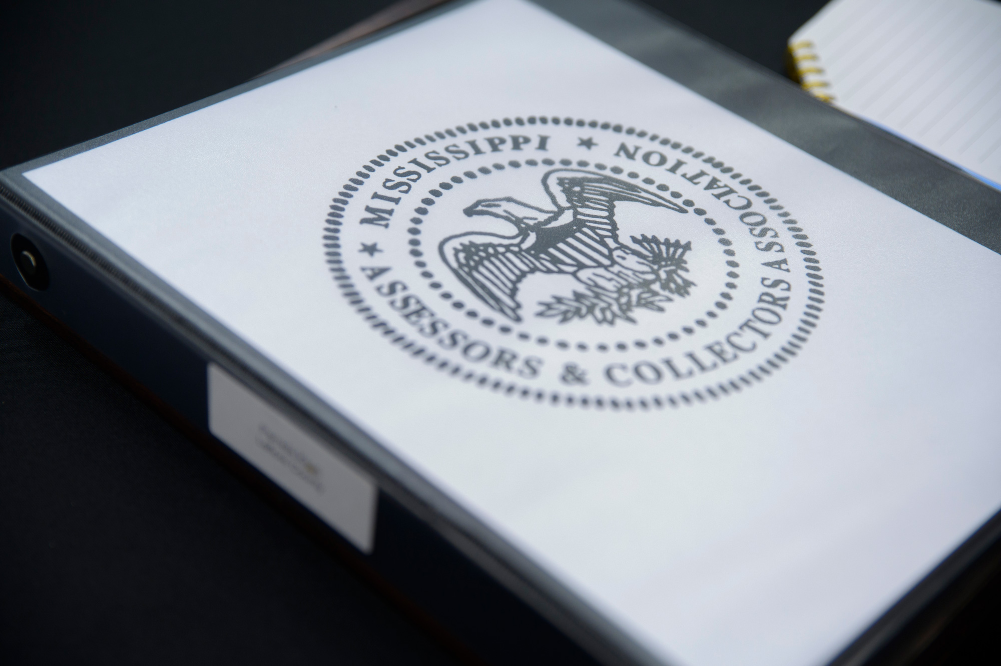 A notebook cover with a printed seal listing “Mississippi Assessors and Collectors Association."