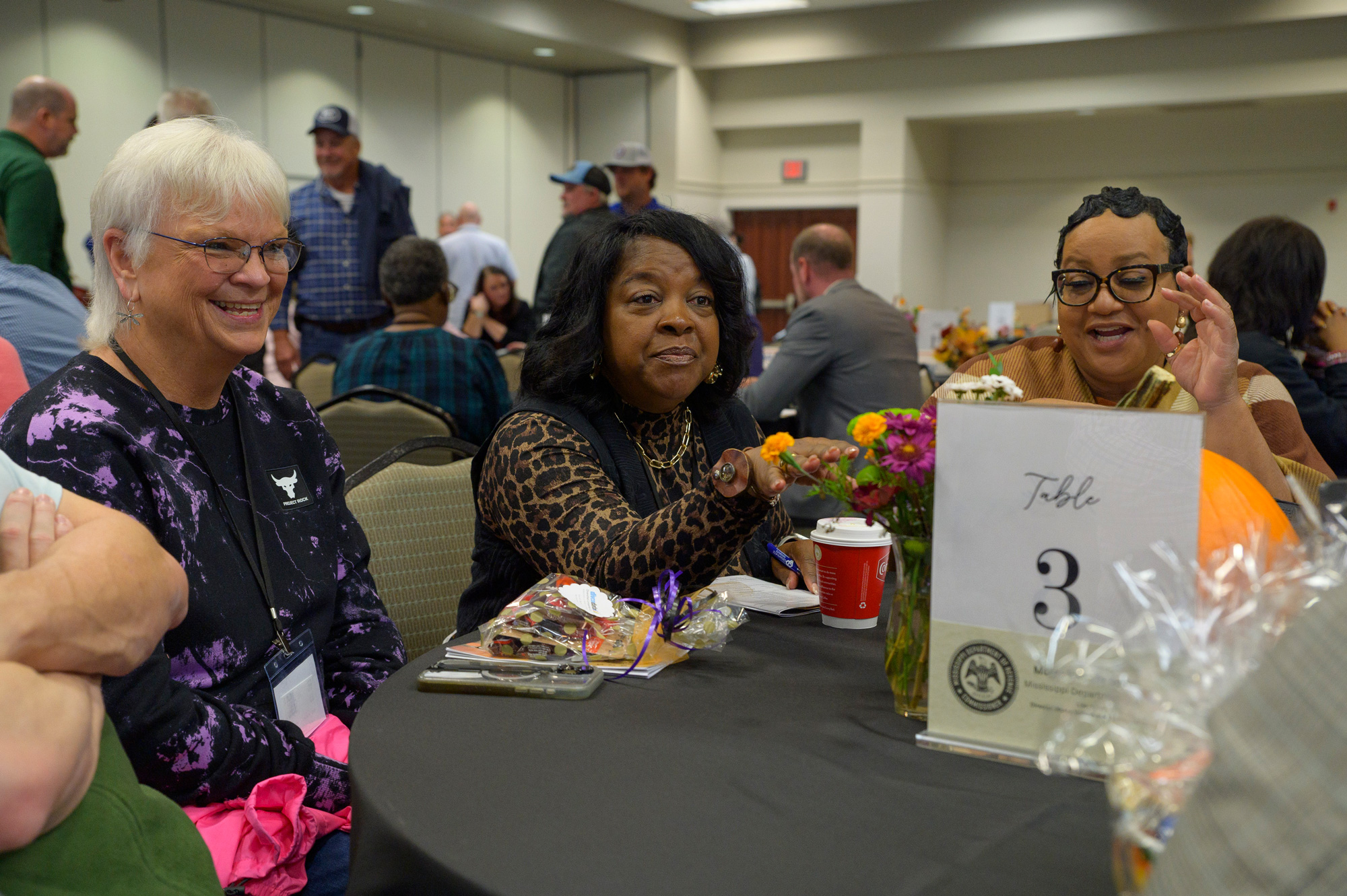 One person listens while two others laugh.