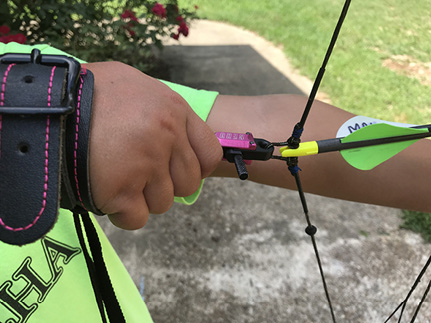 Close-up of a hand pulling back the bowstring.