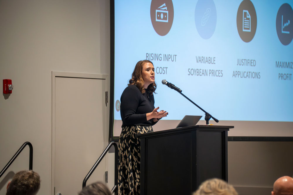 A person standing and gesturing at a podium.