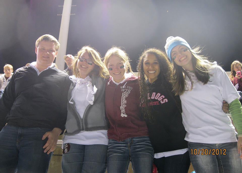 A group of young people standing in bleachers.
