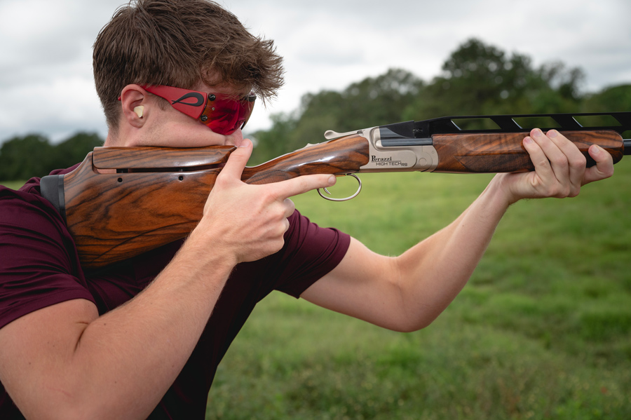 A man wearing safety glasses and holding a rifle.