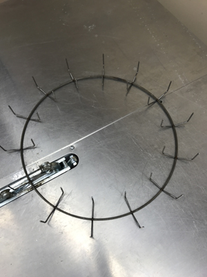 A round metal device with clamps spaced evenly around.