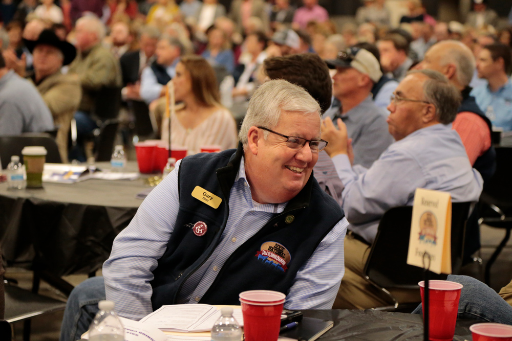 A smiling person seated at a table.