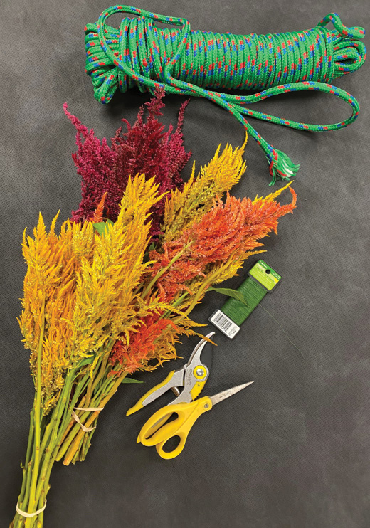 Flower stems and garland materials set out on a table. 